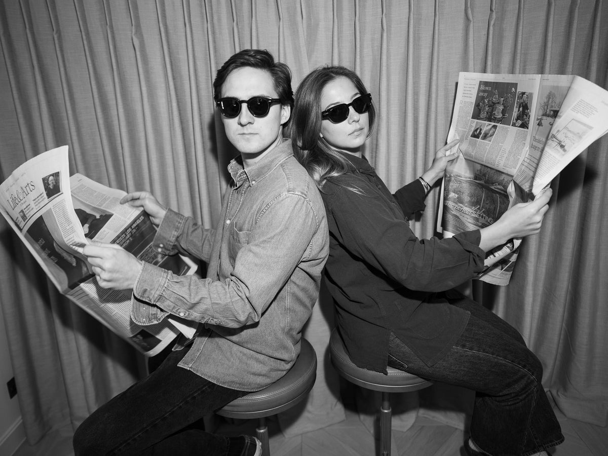A black-and-white portrait of Studio Clint's two founders wearing sunglasses.