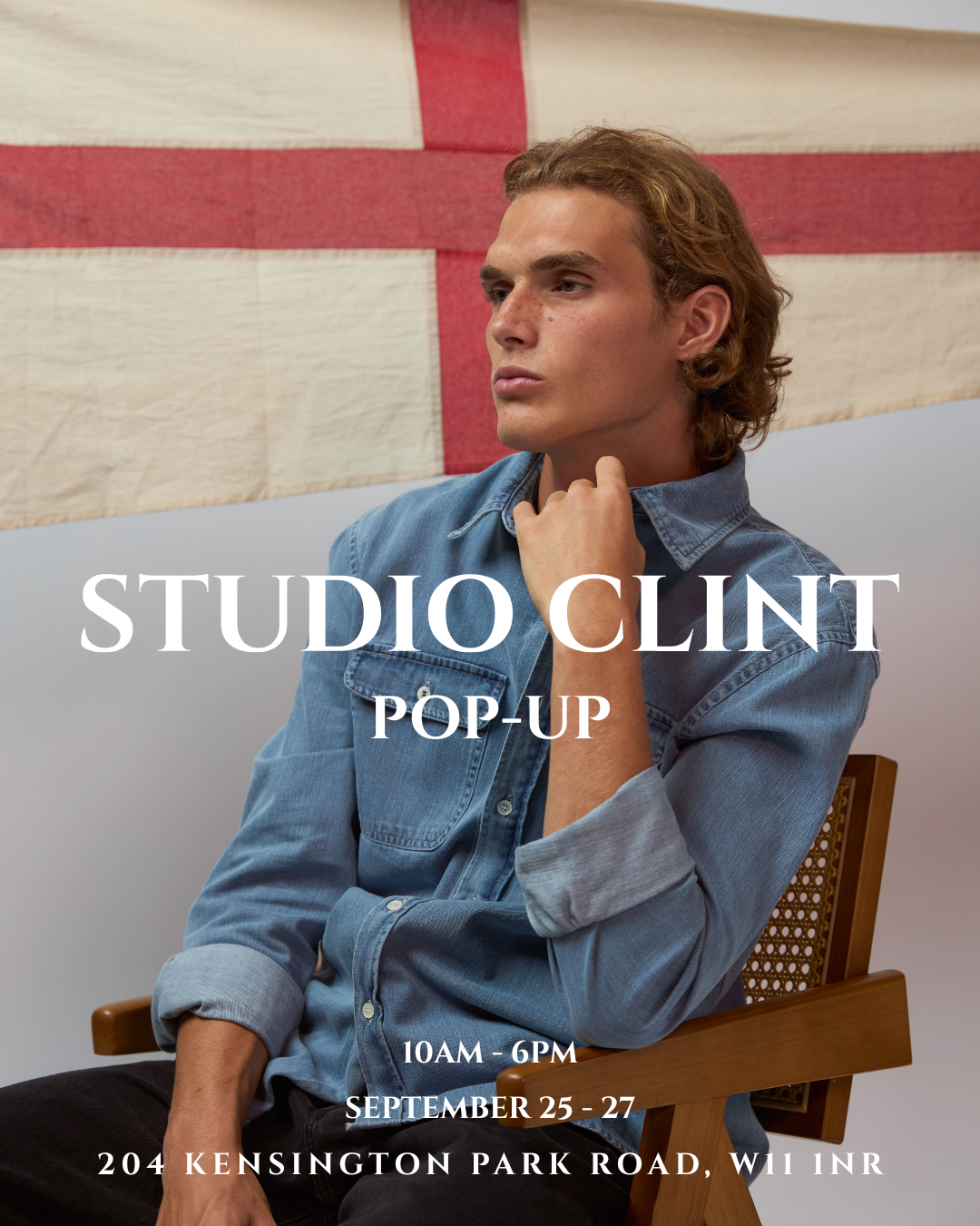 A man in a denim shirt seated in front of a large England flag, promoting the Studio Clint pop-up.