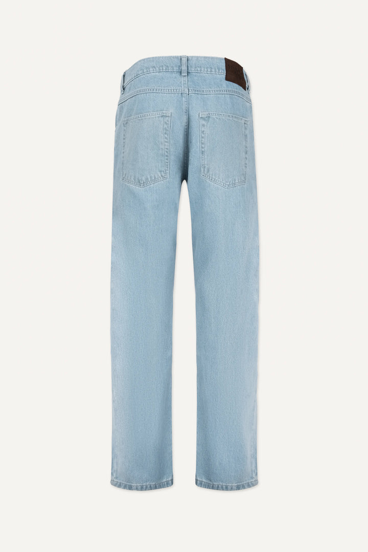 A close-up of light blue denim fabric showing the texture and signature bartack stitching.