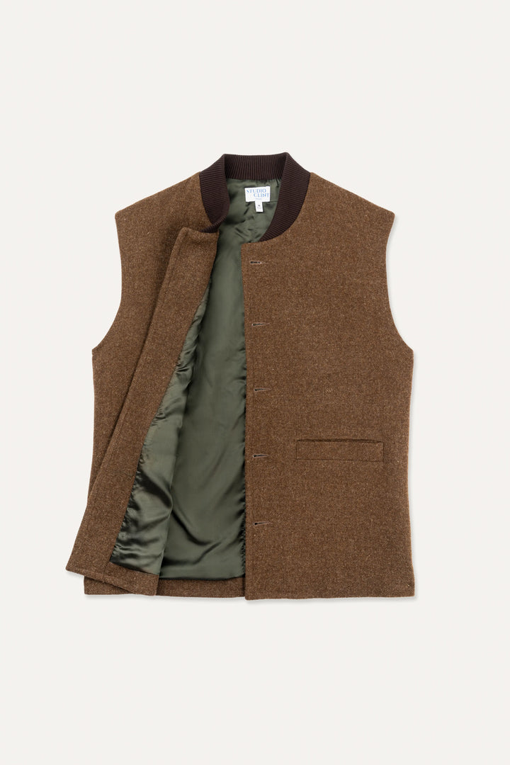 A brown tweed waistcoat vest with a dark brown ribbed collar, featuring an open front that reveals an olive green quilted lining, laid flat against a light off-white background.