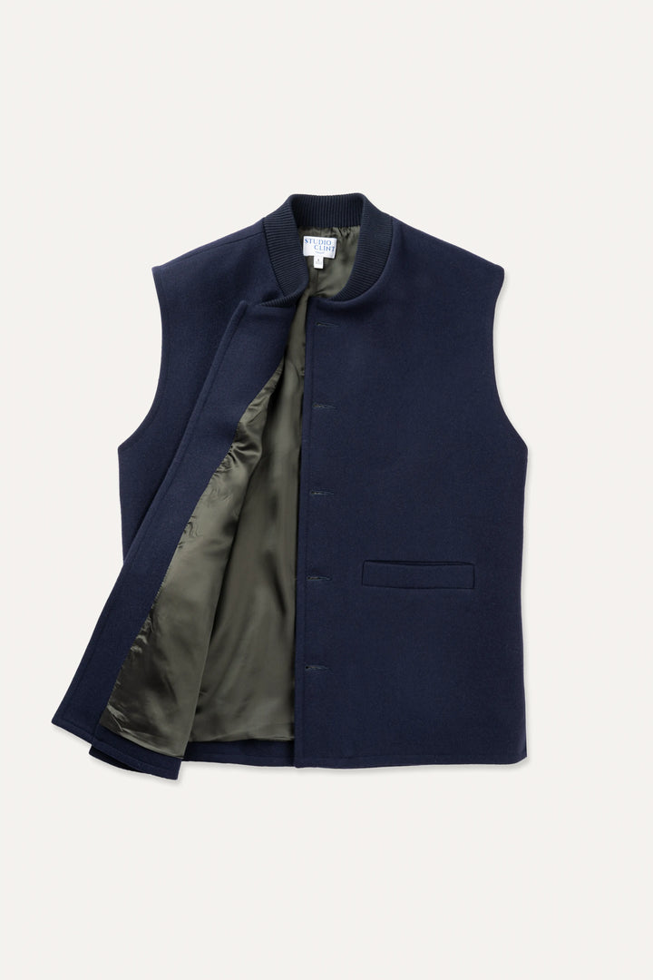 A midnight navy loden-wool vest shown flat, highlighting the ribbed collar and front button closure.